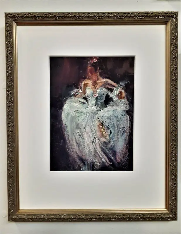 Painting of a ballerina in ornate frame.