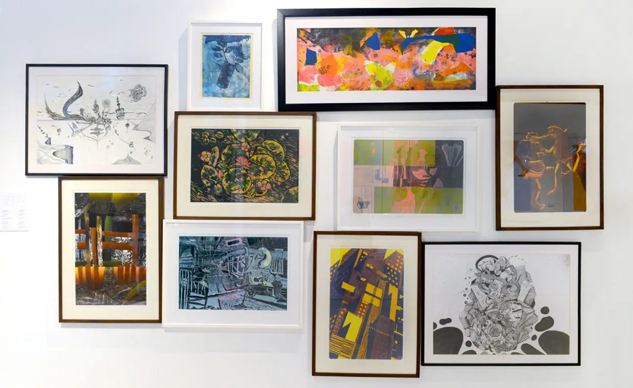 Gallery wall with various framed artworks.