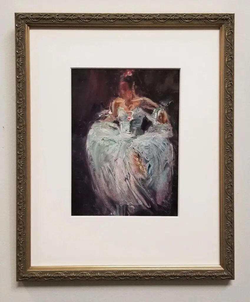 Framed impressionist painting of a seated figure.