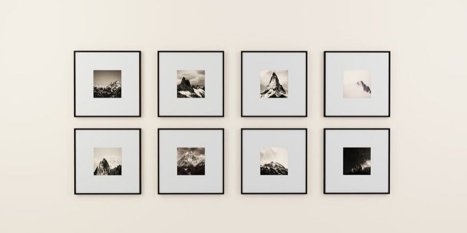 Framed black-and-white mountain photographs on wall.